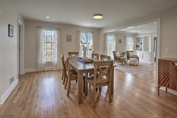 a view of a a dining room with furniture window and wooden floor