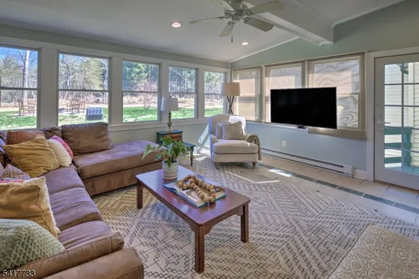 a living room with furniture a flat screen tv and a large window