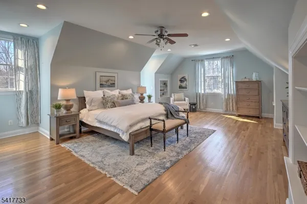 a bedroom with a bed lamps and wooden floor