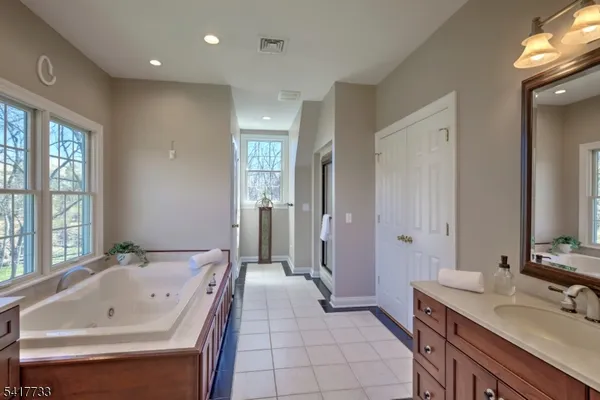 a bathroom with a tub sink and mirror