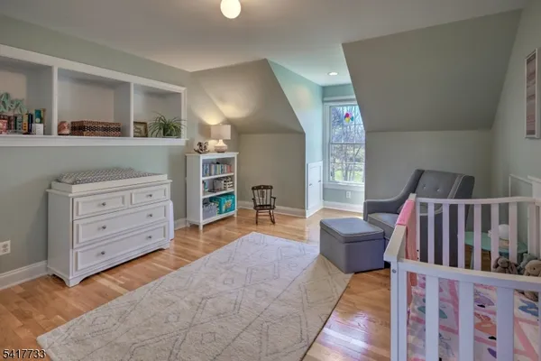 a living room with furniture and a baby crib