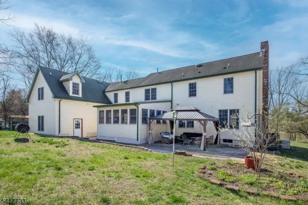 a view of a house with backyard and sitting area