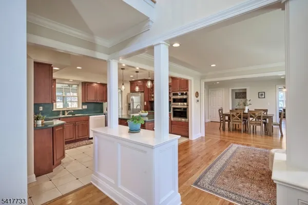 a large white kitchen with lots of counter top space and stainless steel appliances