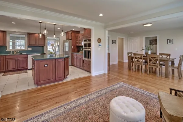 a living room with furniture wooden floor and a kitchen view