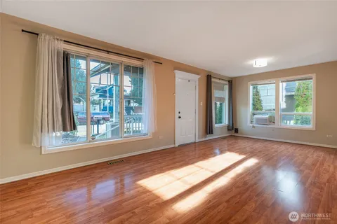 a view of a big room with wooden floor and windows