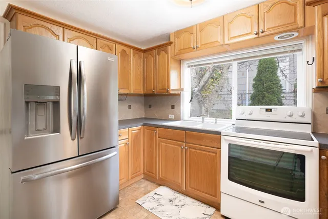 a kitchen with stainless steel appliances a refrigerator sink and cabinets