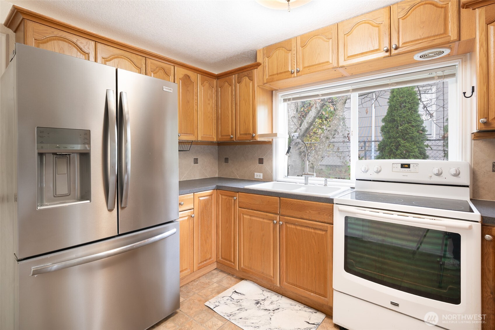 3584 East K Street Tacoma, WA 98404 - Photo 17 of 30 a kitchen with stainless steel appliances a refrigerator sink and cabinets