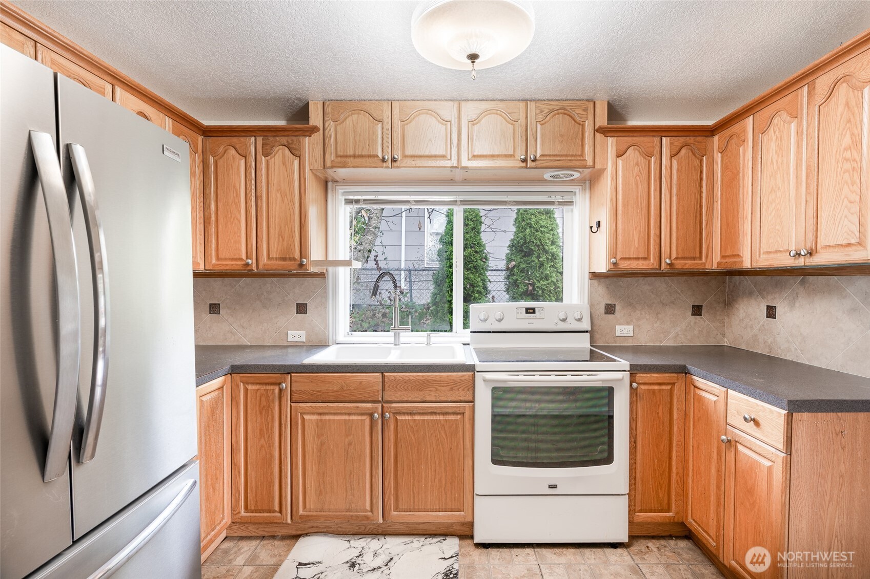 3584 East K Street Tacoma, WA 98404 - Photo 18 of 30 a kitchen with stainless steel appliances granite countertop a refrigerator sink and cabinets