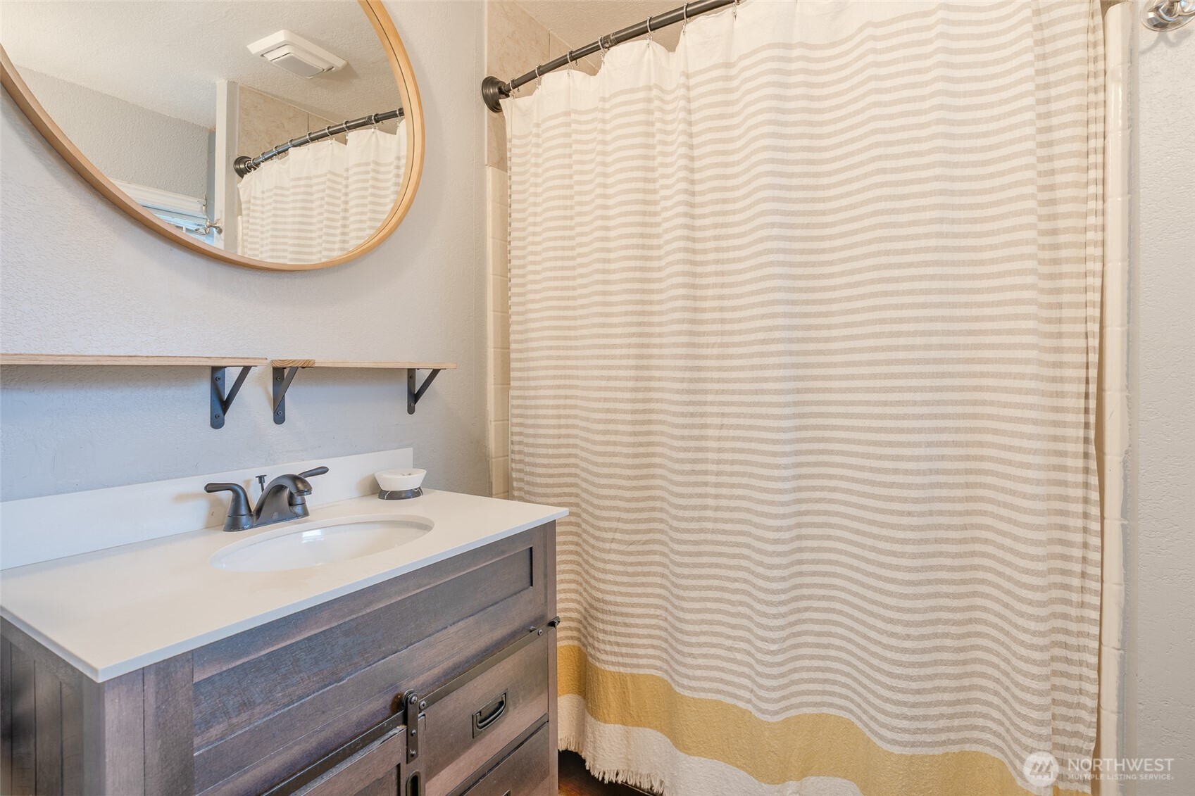 3584 East K Street Tacoma, WA 98404 - Photo 19 of 30 a bathroom with a sink a mirror and a shower