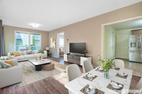 a living room with furniture a flat screen tv and a large window