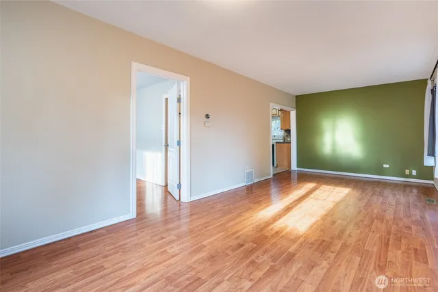 a view of empty room with wooden floor