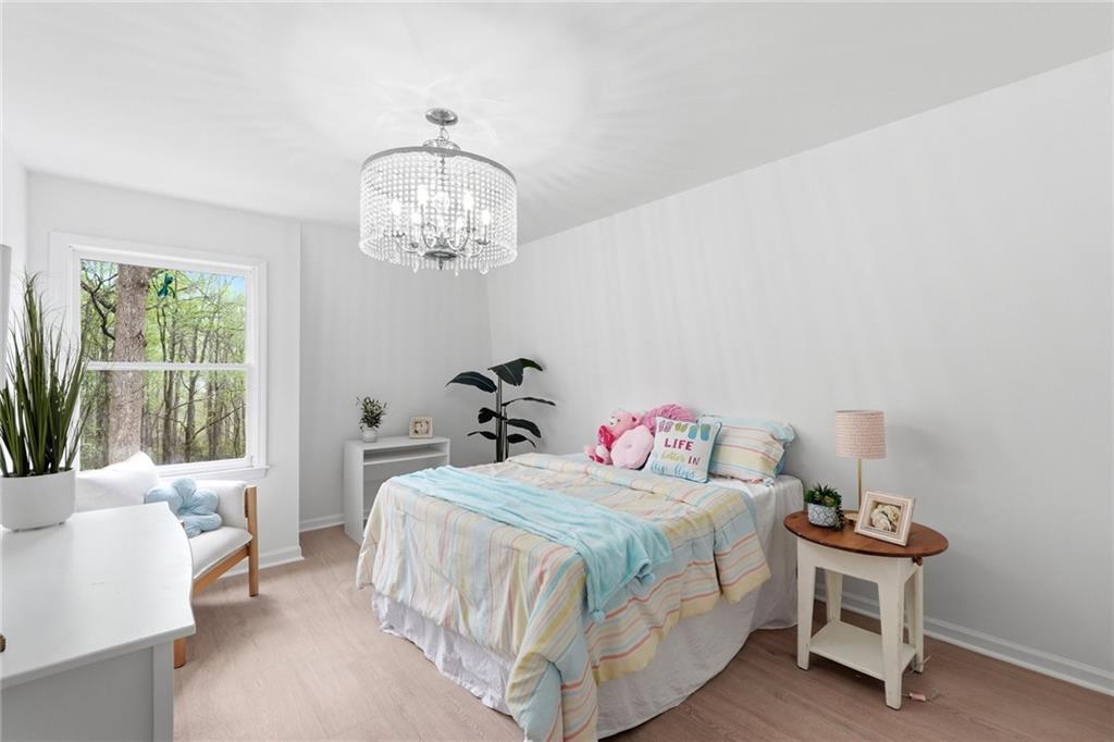 2955 Brookfield Circle Cumming, GA 30040 - Photo 51 of 89 a bedroom with a bed and a chandelier