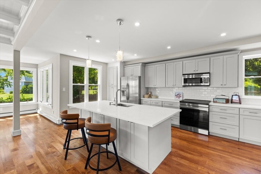 1366 Gardners Neck Road Swansea, MA 02777 - Photo 22 of 35 a kitchen with granite countertop a stove a sink a dining table and chairs