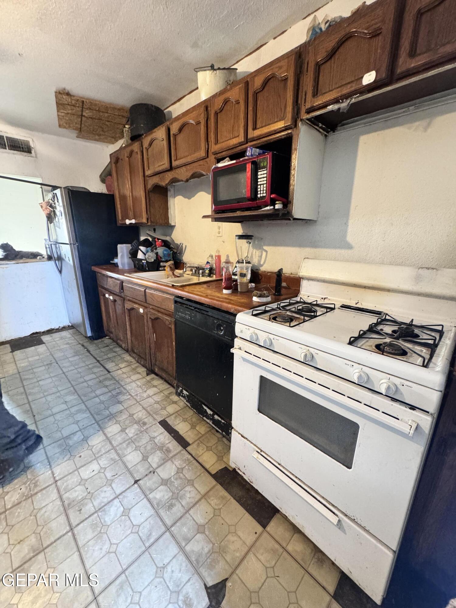 7045 1st Street Canutillo, TX 79835 - Photo 30 of 50 a kitchen with stainless steel appliances granite countertop a stove and a sink