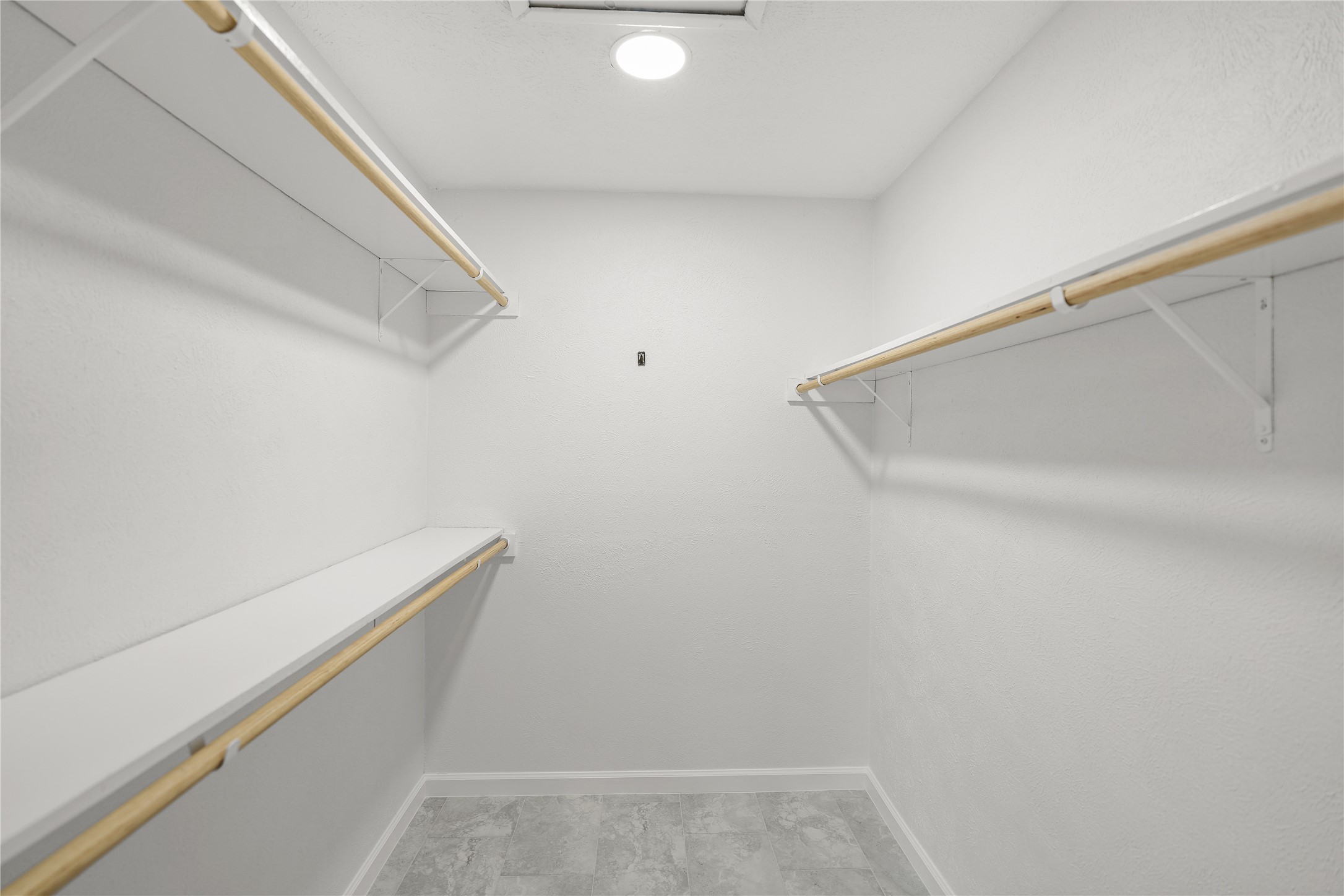 6610 Blue Ridge Drive Richmond, TX 77469 - Photo 17 of 24 This is a spacious walk-in closet with ample shelving, and hanging rods, perfect for organizing clothing and accessories.
