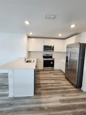 a kitchen with stainless steel appliances a refrigerator sink and microwave