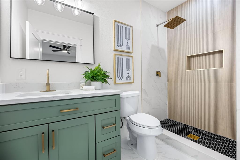 1014 Bolivar Street Denton, TX 76201 - Photo 23 of 36 a bathroom with a toilet a sink and mirror