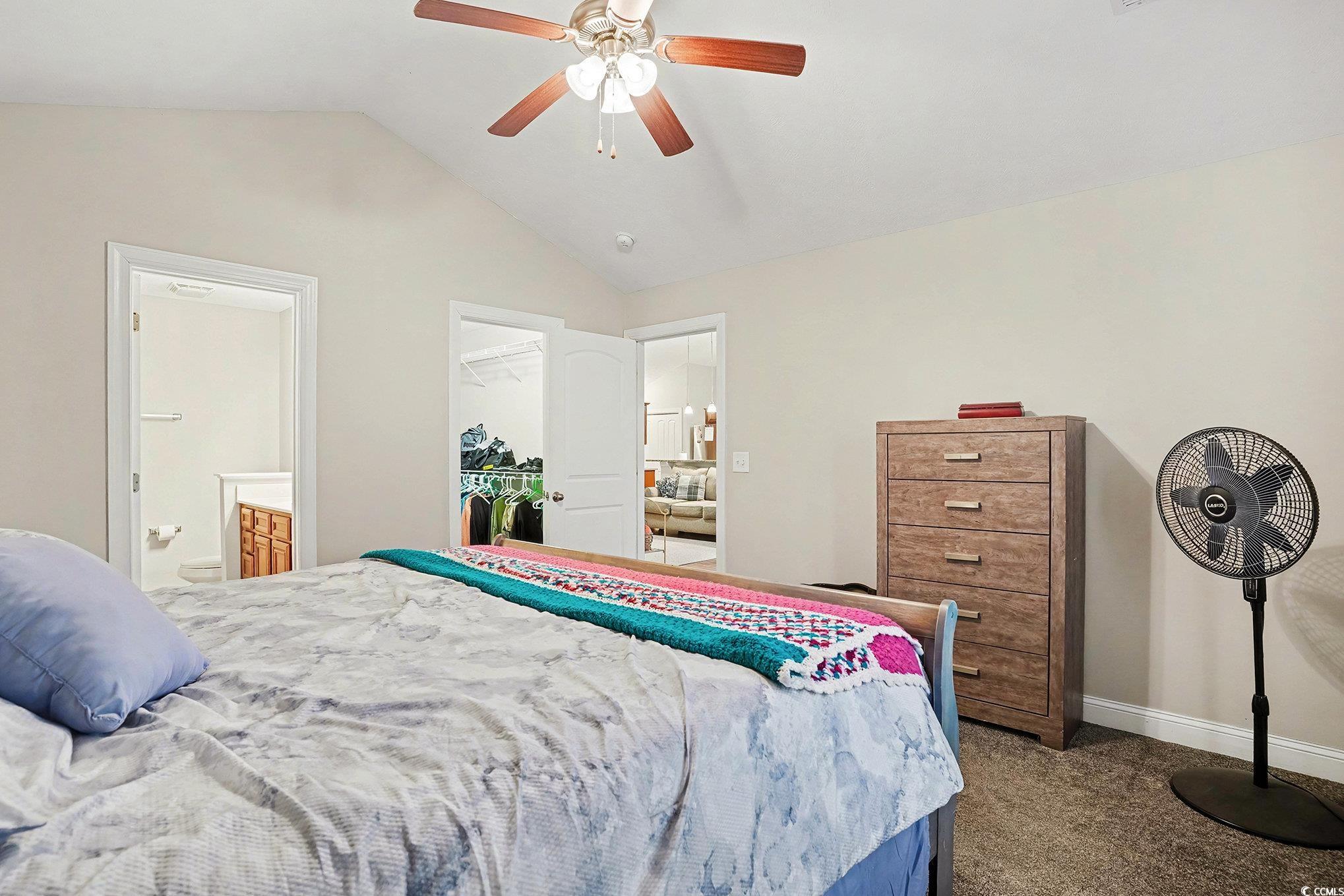 216 Camrose Way Myrtle Beach, SC 29588 - Photo 17 of 32 Bedroom featuring dark carpet, vaulted ceiling, a spacious closet, ensuite bath, and a ceiling fan