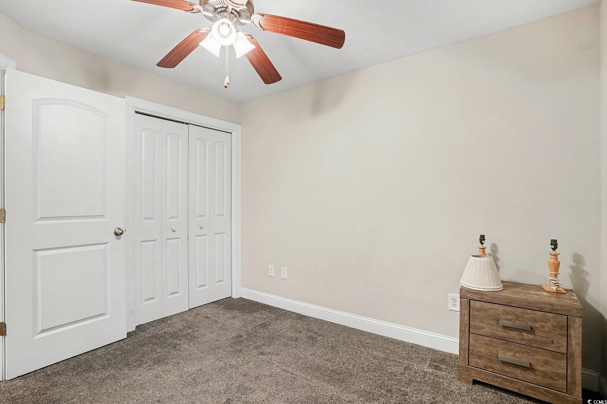 216 Camrose Way Myrtle Beach, SC 29588 - Photo 24 of 32 Unfurnished bedroom featuring dark carpet, a closet, and ceiling fan