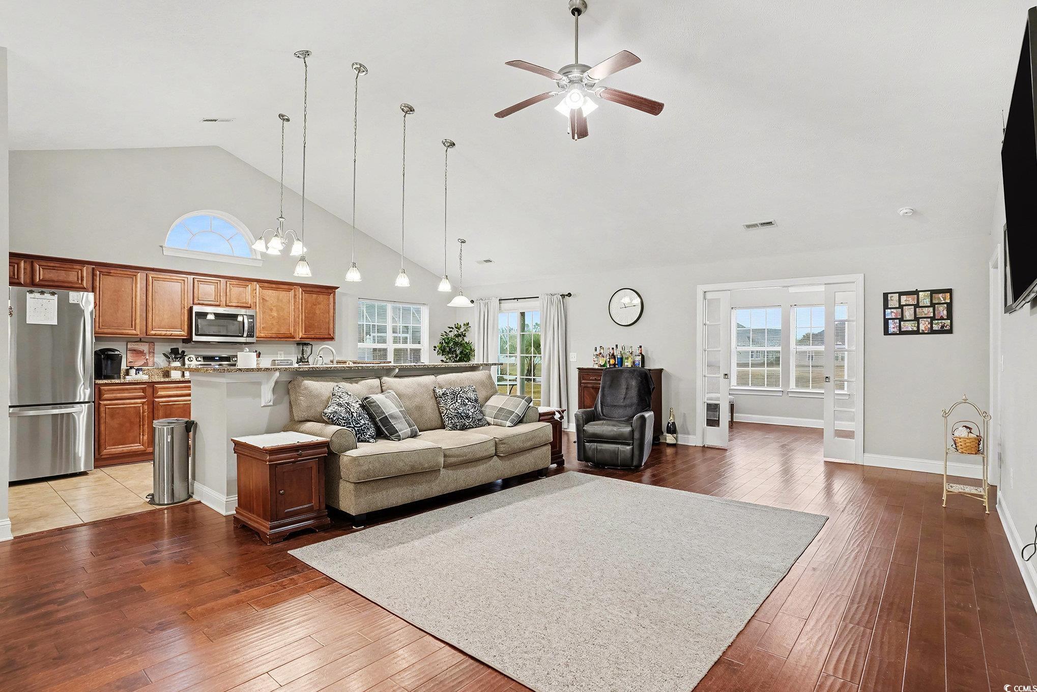 216 Camrose Way Myrtle Beach, SC 29588 - Photo 7 of 32 Living area featuring high vaulted ceiling, a ceiling fan, dark wood-style floors, and a chandelier