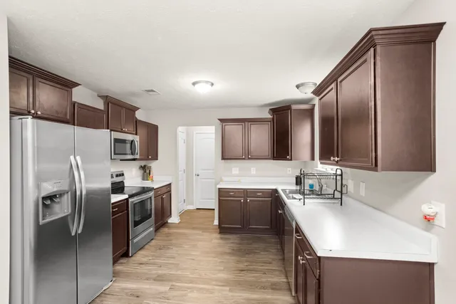 a kitchen with stainless steel appliances granite countertop a sink stove and refrigerator