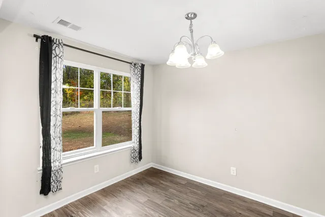 a view of a room with wooden floor and windows