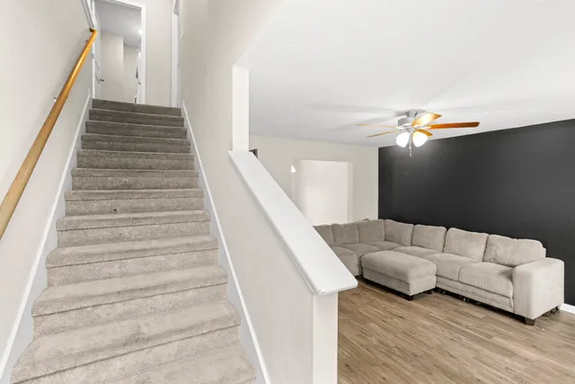 a living room with furniture and stairs