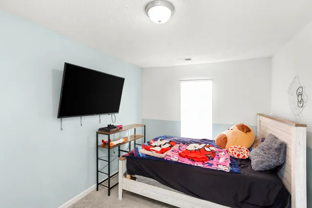 a bedroom with a bed and flat screen tv
