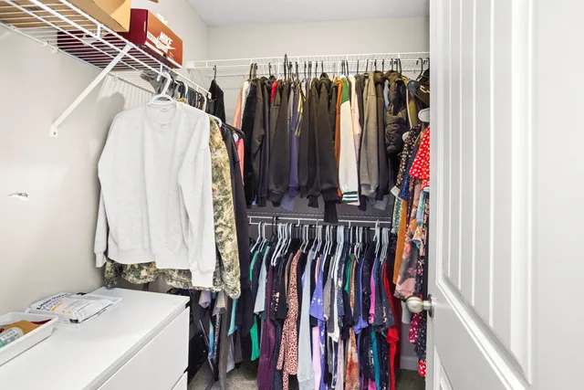 a view of walk in closet with clothes