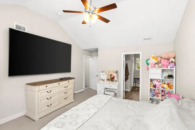 a bedroom with a bed and a flat tv screen on dresser