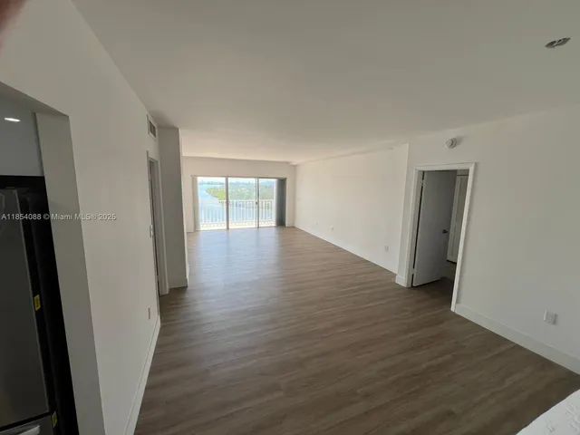 a view of empty room with wooden floor and cabinets