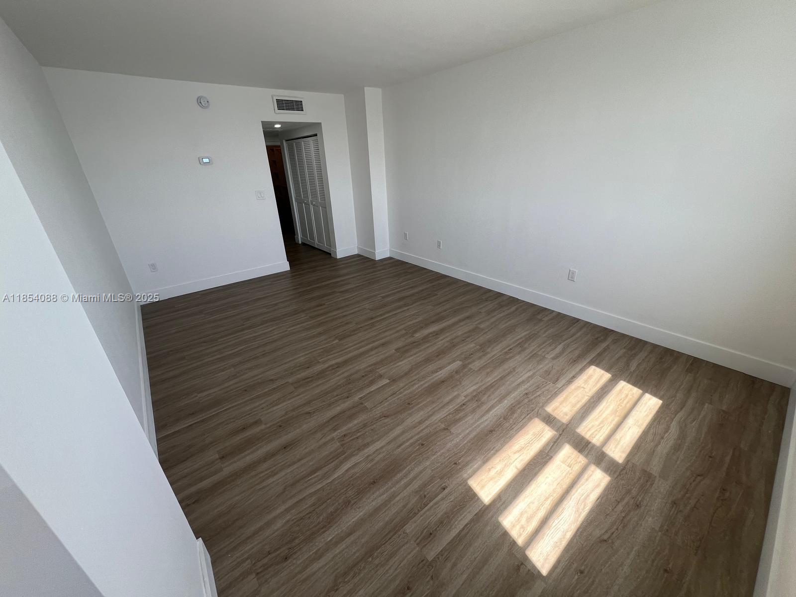 500 Bayview Drive, Unit 1120 Sunny Isles Beach, FL 33160 - Photo 21 of 46 a view of empty room with wooden floor and fan