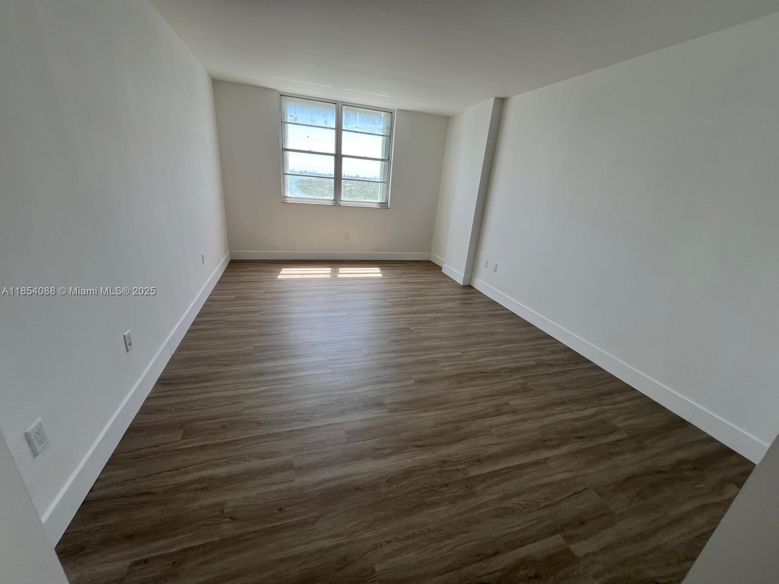 500 Bayview Drive, Unit 1120 Sunny Isles Beach, FL 33160 - Photo 24 of 46 wooden floor in an empty room with a window