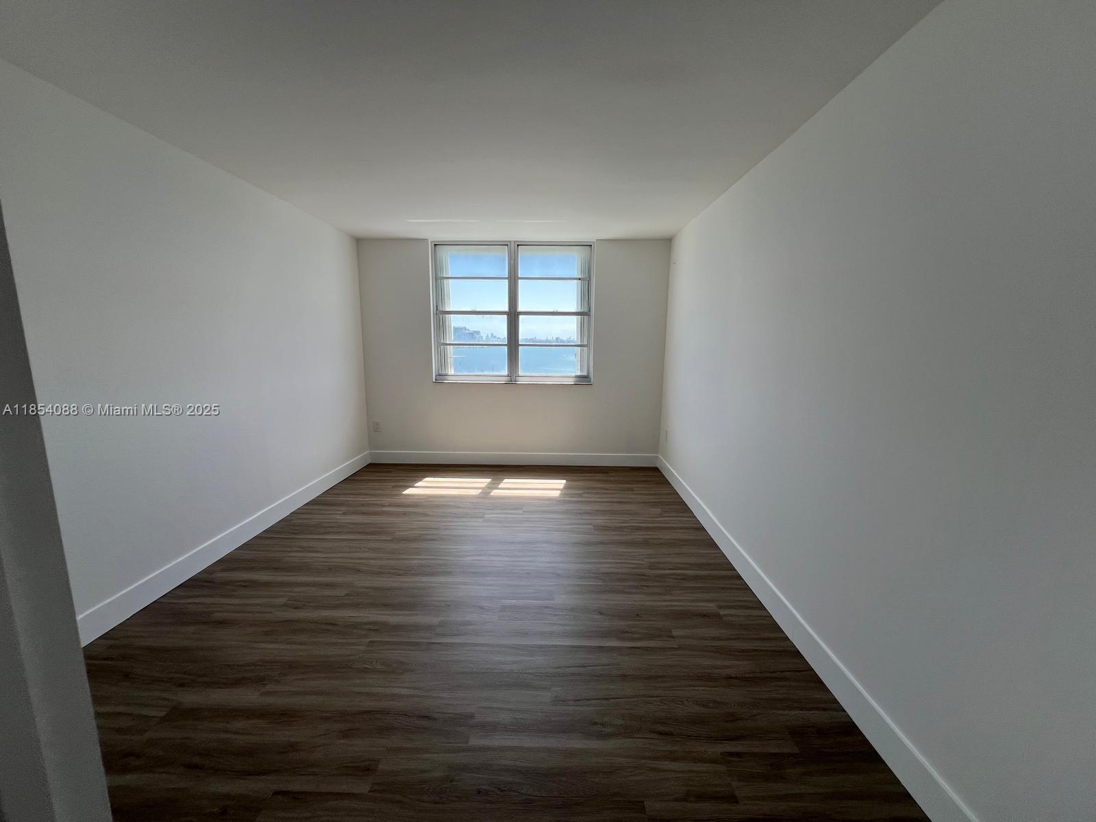 500 Bayview Drive, Unit 1120 Sunny Isles Beach, FL 33160 - Photo 35 of 46 a view of an empty room with wooden floor and window