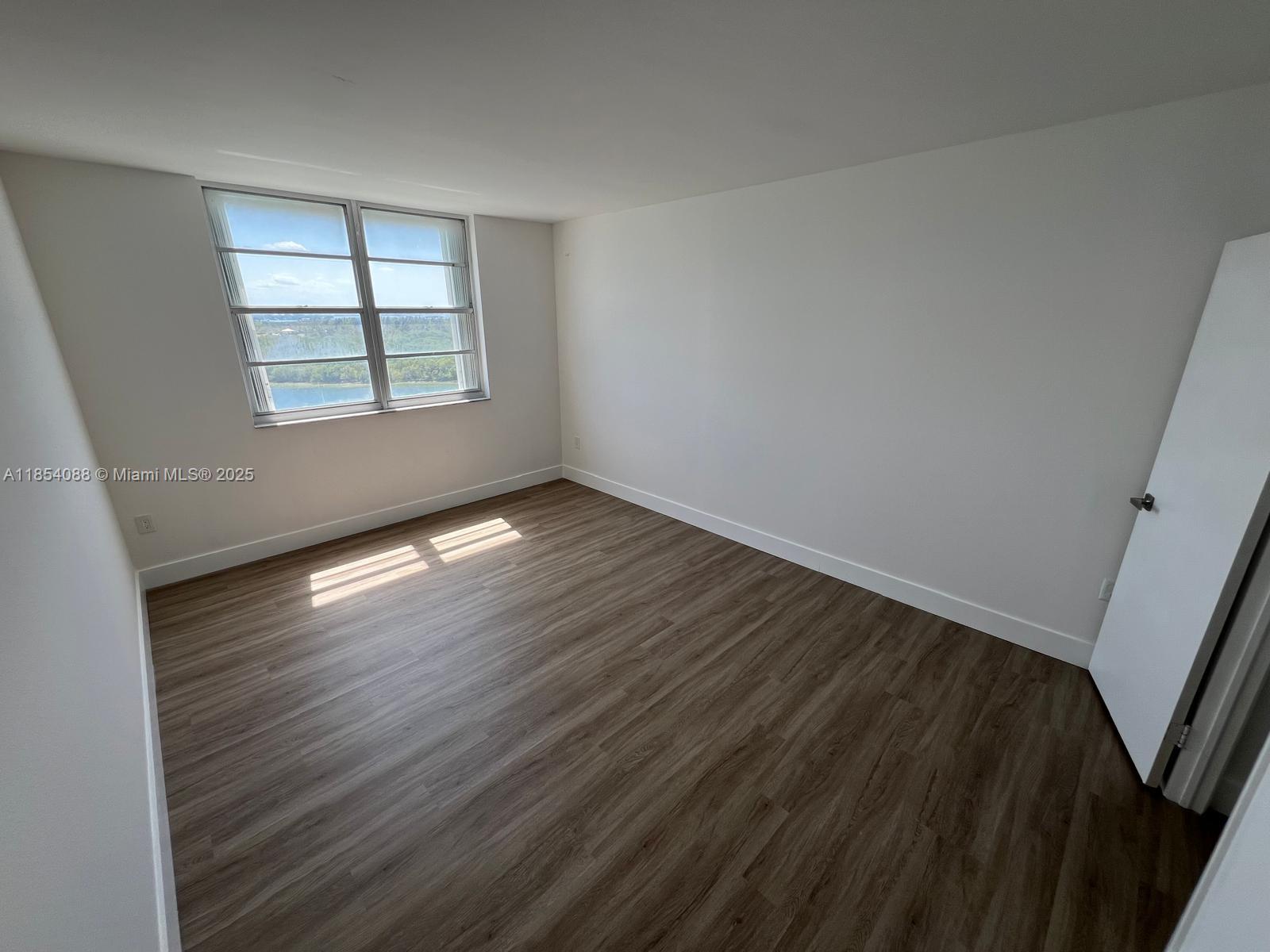 500 Bayview Drive, Unit 1120 Sunny Isles Beach, FL 33160 - Photo 37 of 46 wooden floor in an empty room with a window