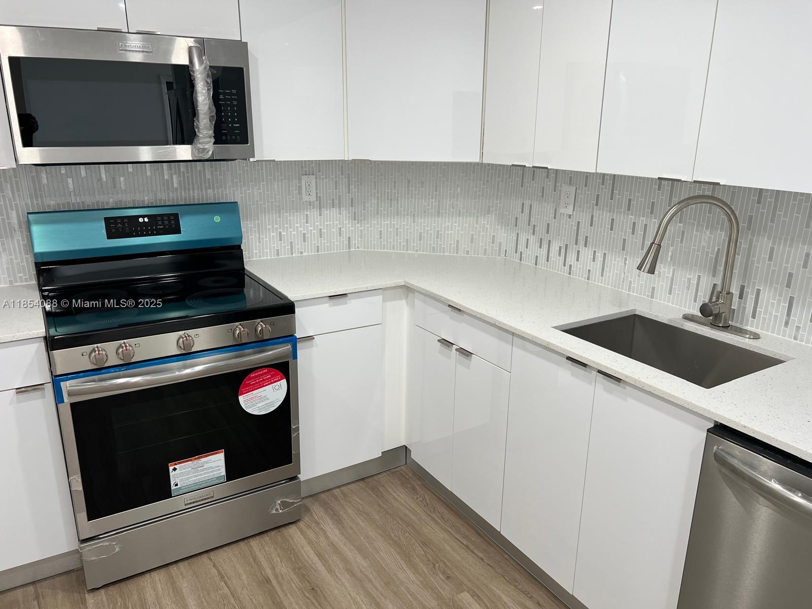 500 Bayview Drive, Unit 1120 Sunny Isles Beach, FL 33160 - Photo 4 of 46 a kitchen with a stove and a microwave