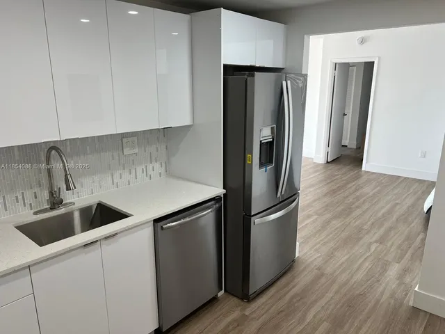 a kitchen with stainless steel appliances granite countertop a refrigerator and a sink