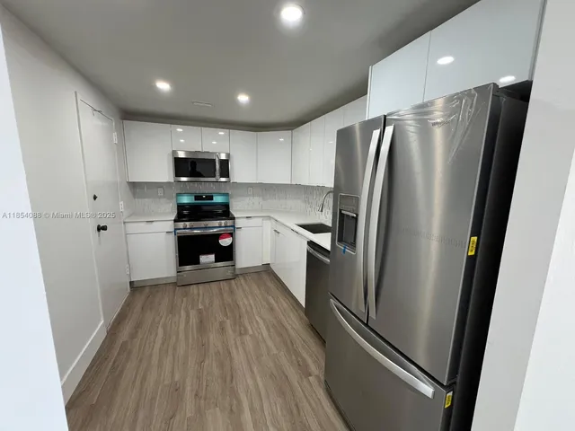 a kitchen with stainless steel appliances a refrigerator and a stove top oven