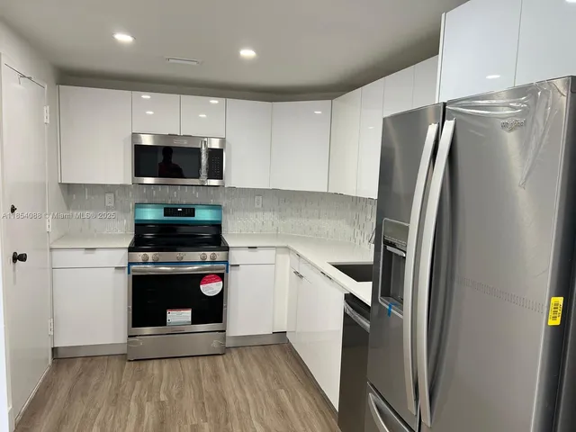 a kitchen with stainless steel appliances a refrigerator sink and microwave