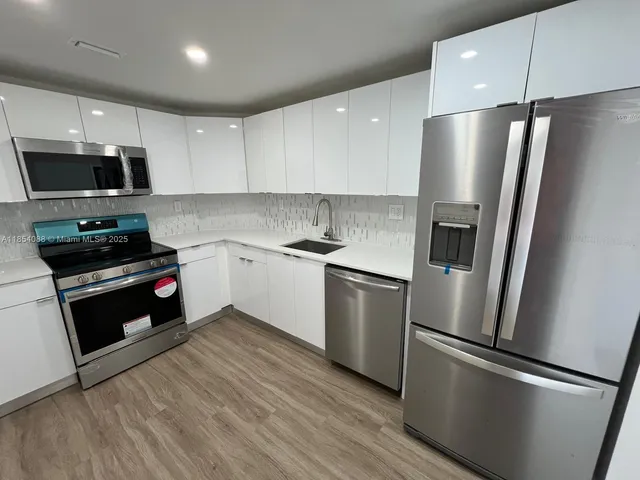 a kitchen with stainless steel appliances and refrigerator