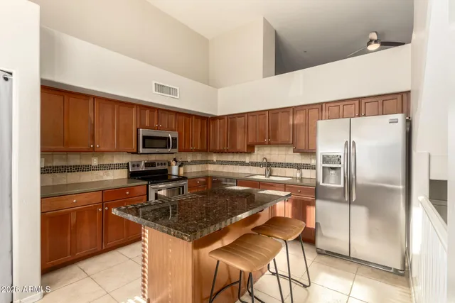 a kitchen with stainless steel appliances granite countertop a sink stove microwave and refrigerator