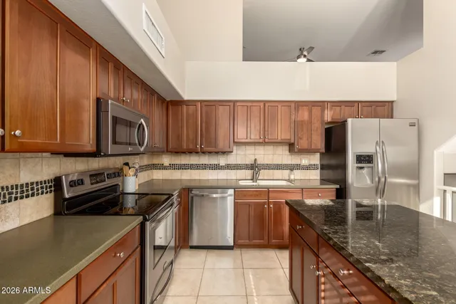a kitchen with stainless steel appliances granite countertop a stove a sink and a microwave