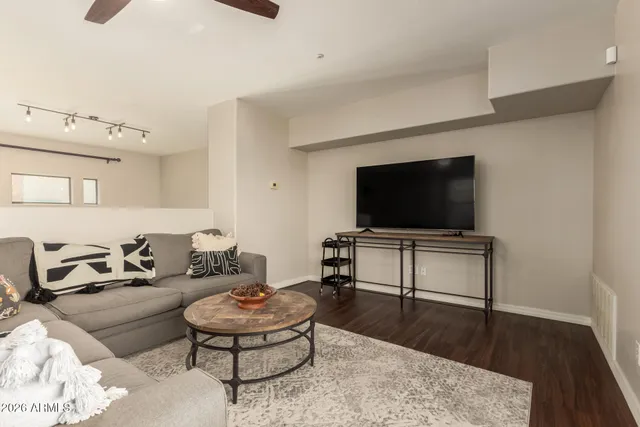 a living room with furniture and a wooden floor