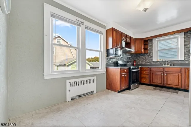 a kitchen with stainless steel appliances granite countertop a stove a sink and a refrigerator