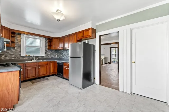 a kitchen with stainless steel appliances granite countertop a refrigerator a sink and dishwasher