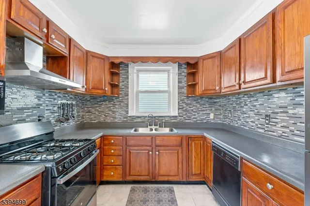 a kitchen with granite countertop a sink a stove and wooden cabinets