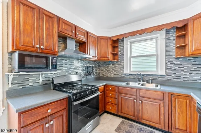 a kitchen with stainless steel appliances granite countertop a sink stove and cabinets
