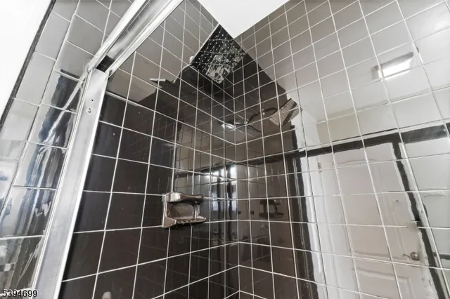 a bathroom with a glass door shower and a mirror
