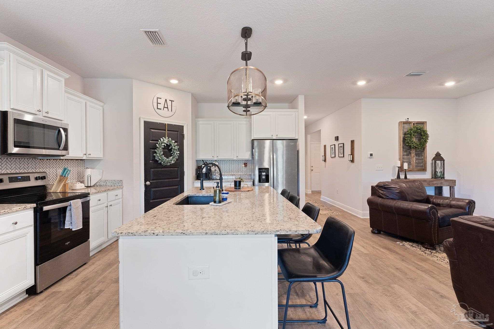 8038 Burnside Loop Pensacola, FL 32526 - Photo 20 of 44 a kitchen with granite countertop kitchen island stainless steel appliances a stove sink microwave and refrigerator