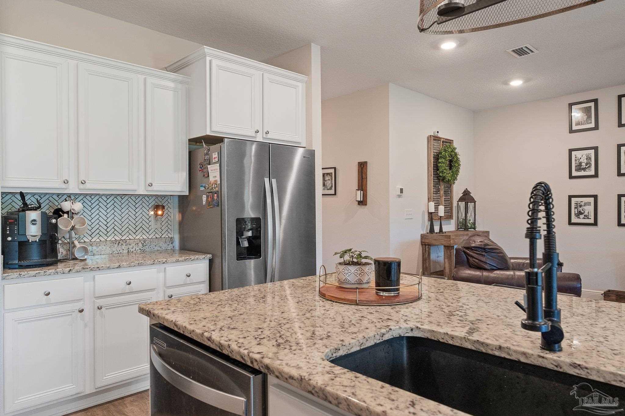 8038 Burnside Loop Pensacola, FL 32526 - Photo 23 of 44 a kitchen with stainless steel appliances granite countertop a sink refrigerator and cabinets
